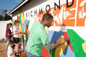 Hamilton Glass paints a mural for the Richmond Strikers. 