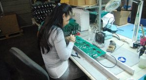 EMSCO employee Vanry Touch assembles a circuit board.