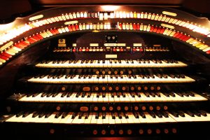The organ console is raised from below the stage and controls instruments hidden above the theater.