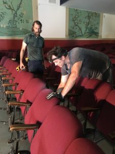 Filmaker Rick Alverson (left) and actor Brian Landis dismantle seats at the Westhampton Theater for use at the Bijou. Photo by Michael Thompson.