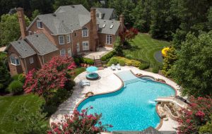 The property features a walk-in heated pool with a hot tub, stone feature with a water slide, and nearly 300-square-foot pool house. (Courtesy CVRMLS)