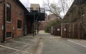 NFA's original suit claims the parking spaces (left), dumpsters (right) and the above HVAC deck are obstructing access to their property ahead. (J. Elias O'Neal)