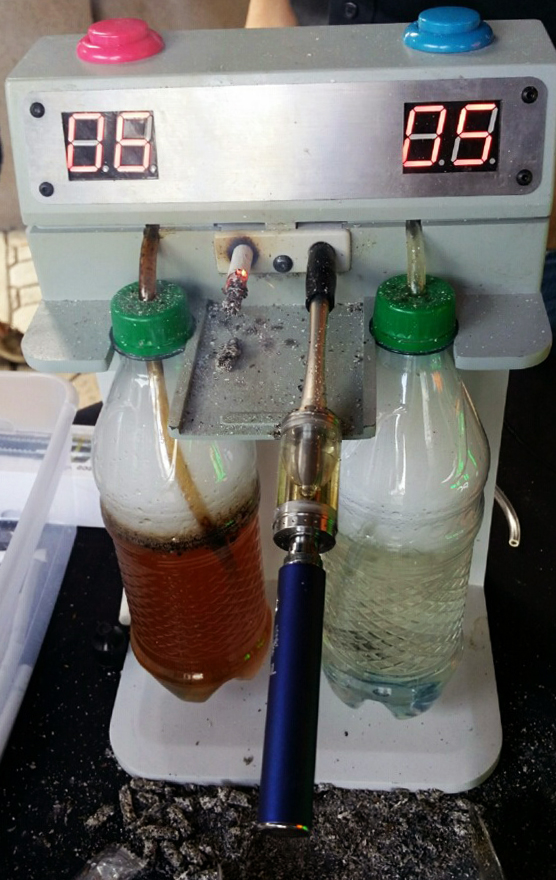 Avail's demonstration rigged up a "puffing machine" in Carytown that filters smoke from traditional cigarettes and e-cigarette vapor through bottles of water. The bottle on the right shows changes after the machine "smoked" four packs of normal cigarettes.
