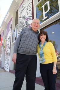 The pair in front of their downtown office, with its tattooed exterior behind them.  